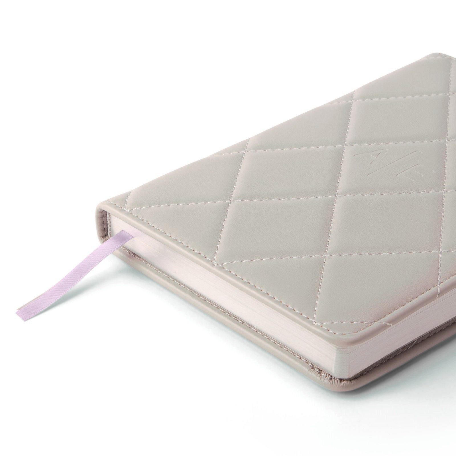 The debossed monogram and stitched edge of a notebook